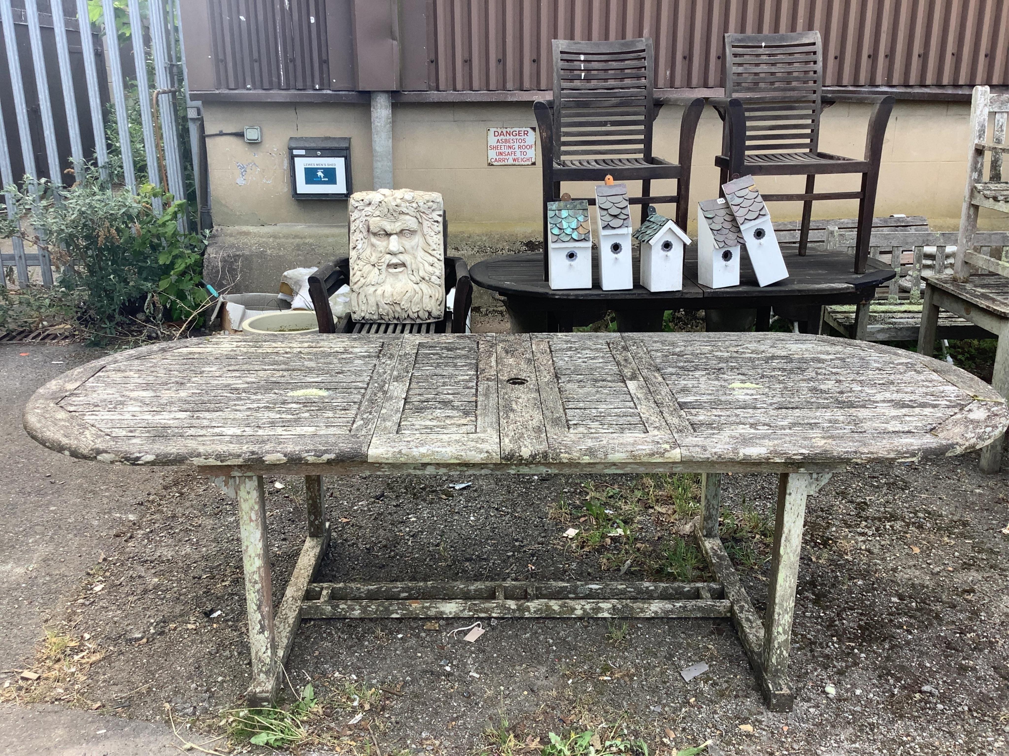 A weathered teak extending garden table, width 260cm extended, depth 99cm, height 72cm
